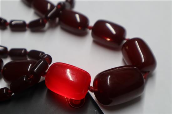 A single strand graduated simulated dark cherry amber necklace, gross weight, 98 grams,